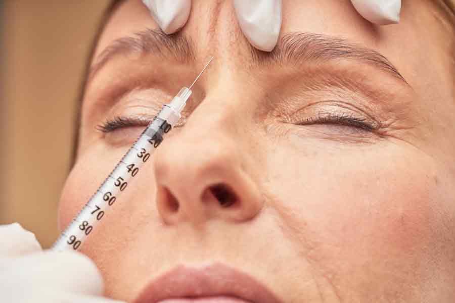 woman receiving a anti wrinkle injection between her eyes