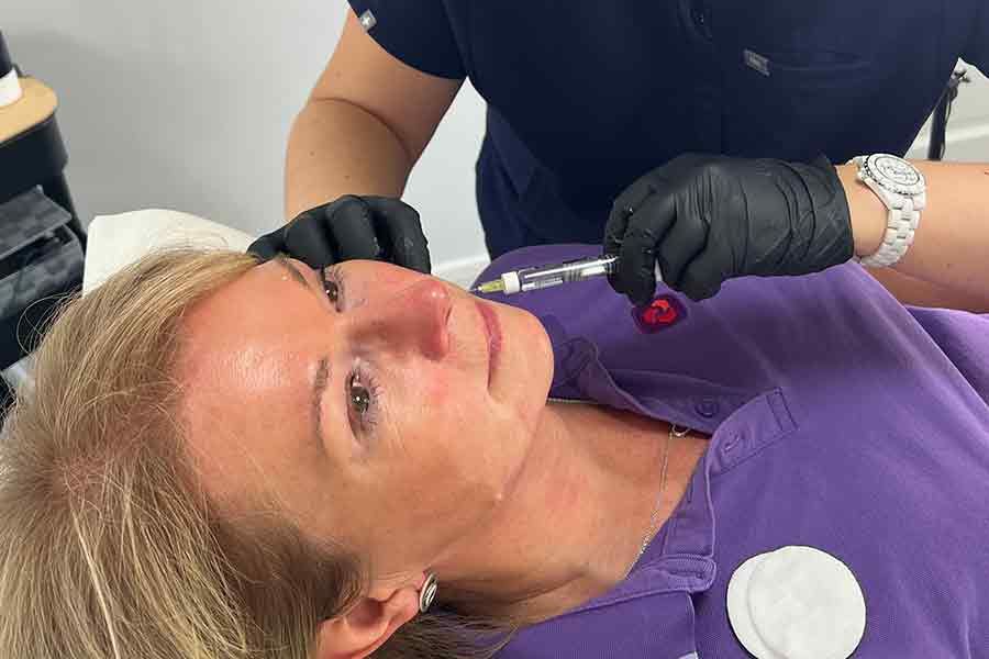 Woman recieving a hydration booster injection in her chin area