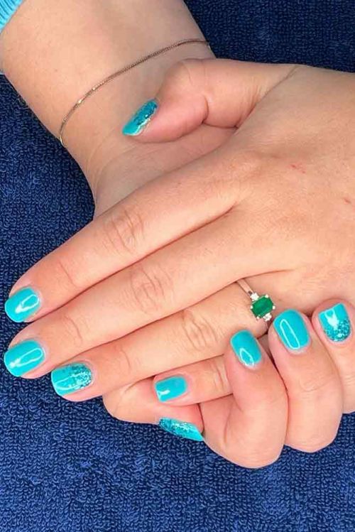 woman's hands showing blue painterd gel finger nails